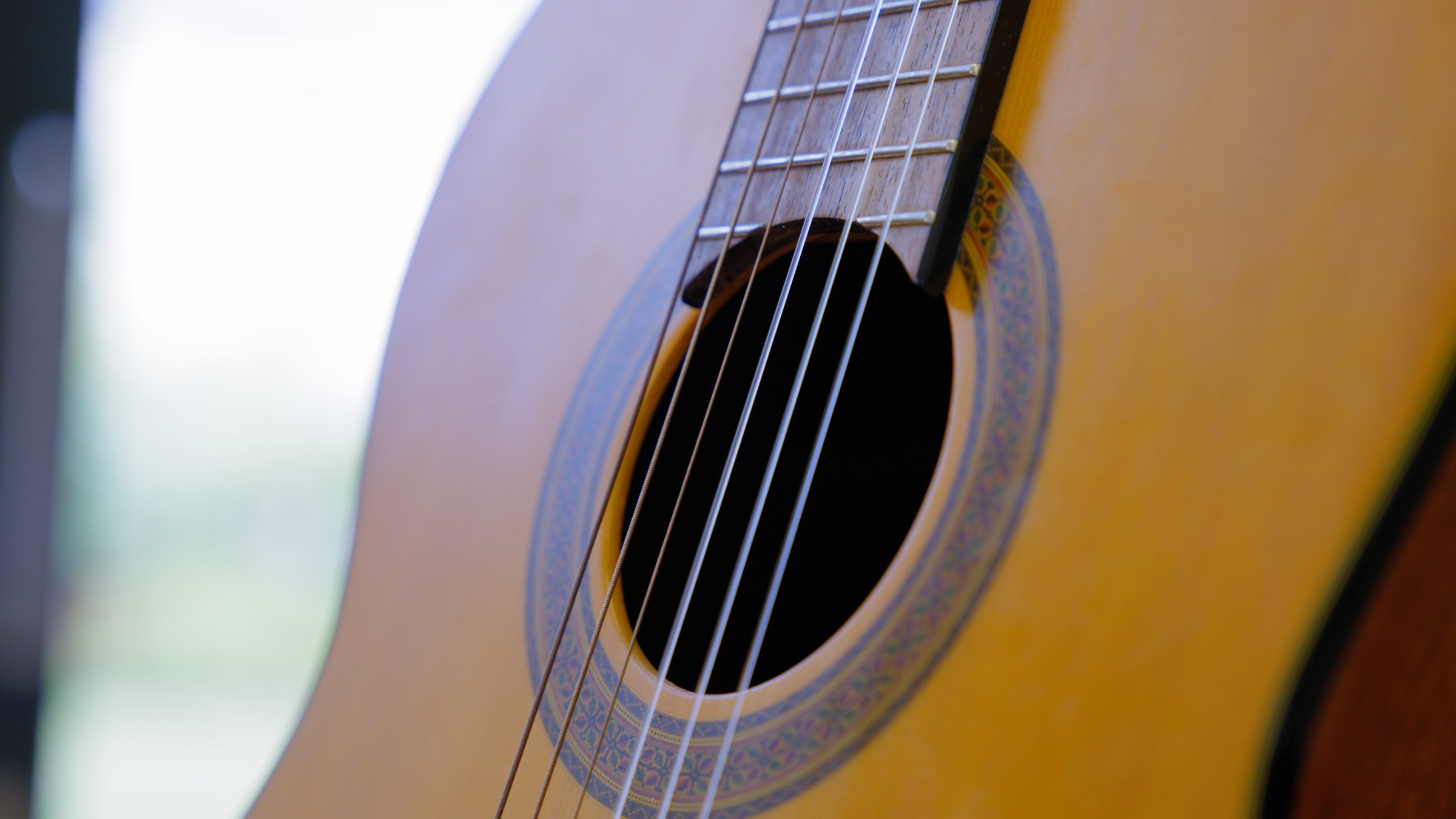 Close-up of a classical guitar soundhole and strings